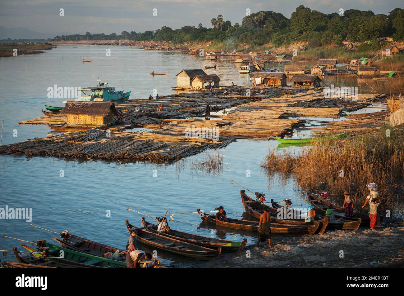 Myanmar, Mandalay, río Irrawaddy, barcos en la orilla del río y bambú para hacer balsas Foto de stock