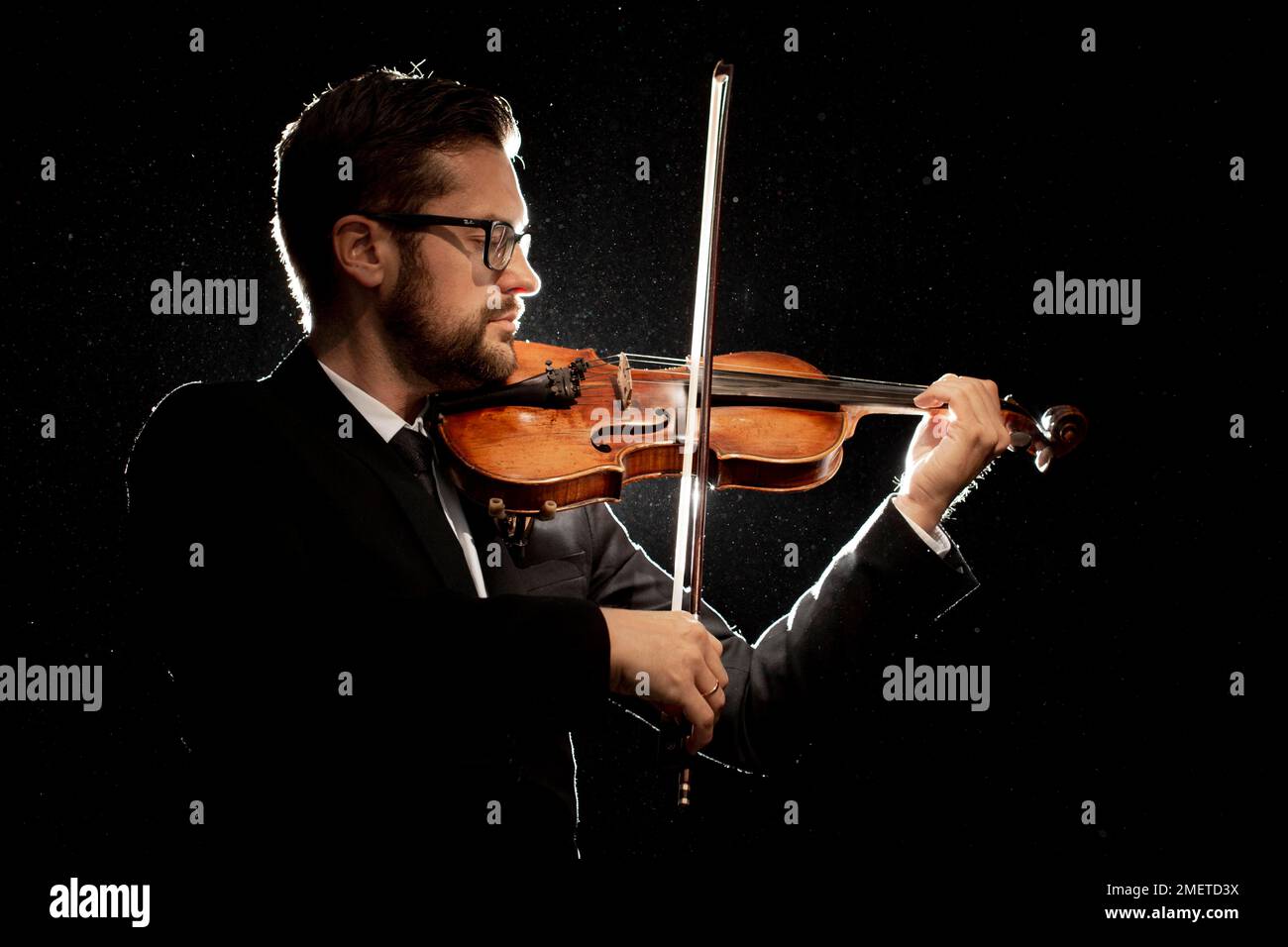 Vista lateral artista masculino tocando violín Foto de stock