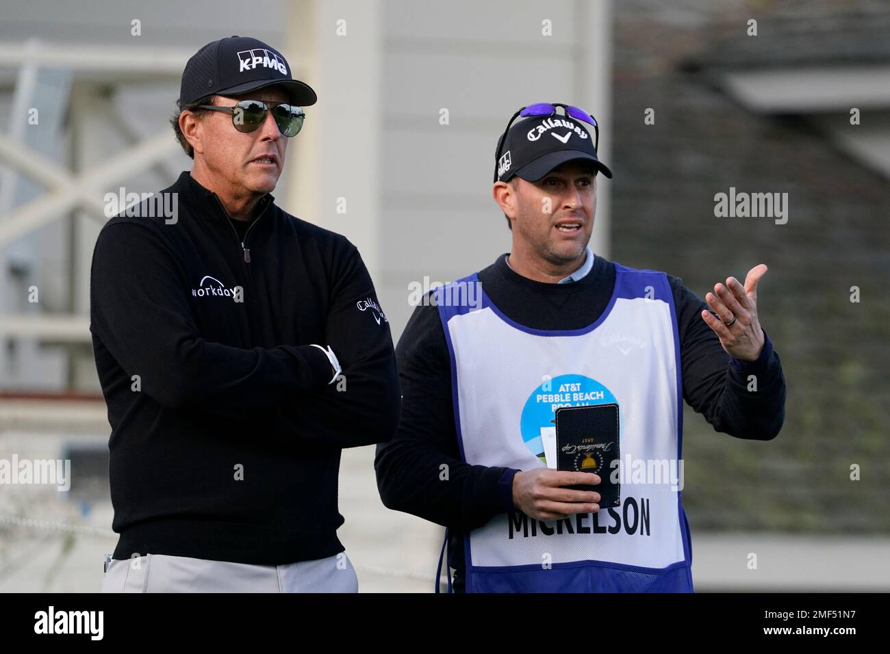 Phil Mickelson, left, stands with his caddie and brother Tim Mickelson