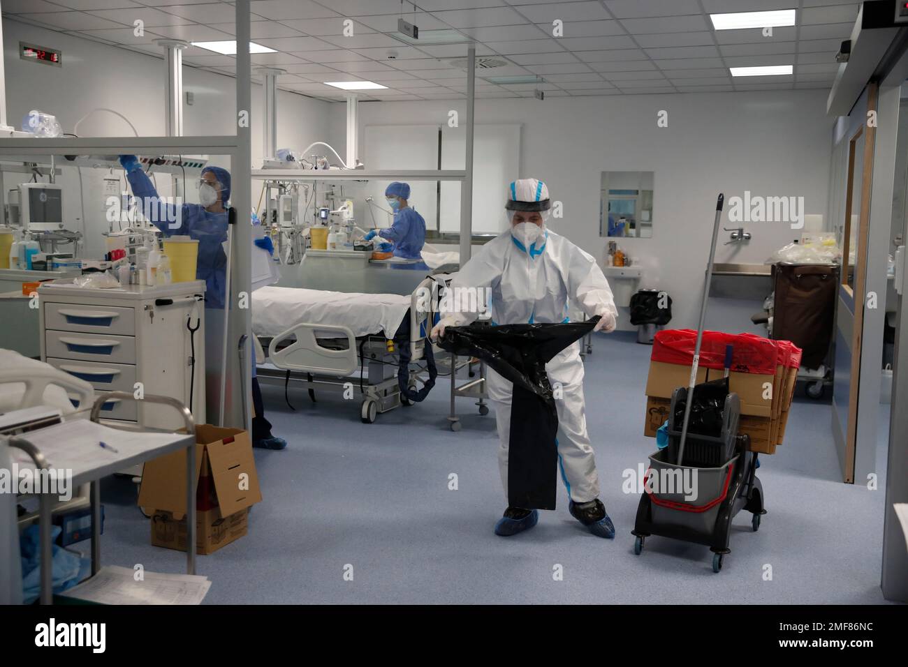 A cleaning worker places a plastic bag as a member of medical staff