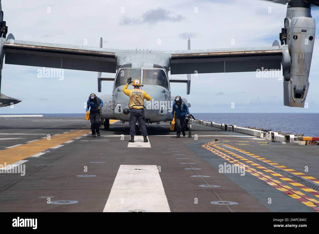 220819-N-XN177-1147 MAR DE FILIPINAS (19 de agosto de 2022) – Los marineros  retiran calzos y cadenas de un avión basculante MV-22 Osprey asignado al  Escuadrón Tiltrotor Medio de Marines (VMM) 262 (reforzado)