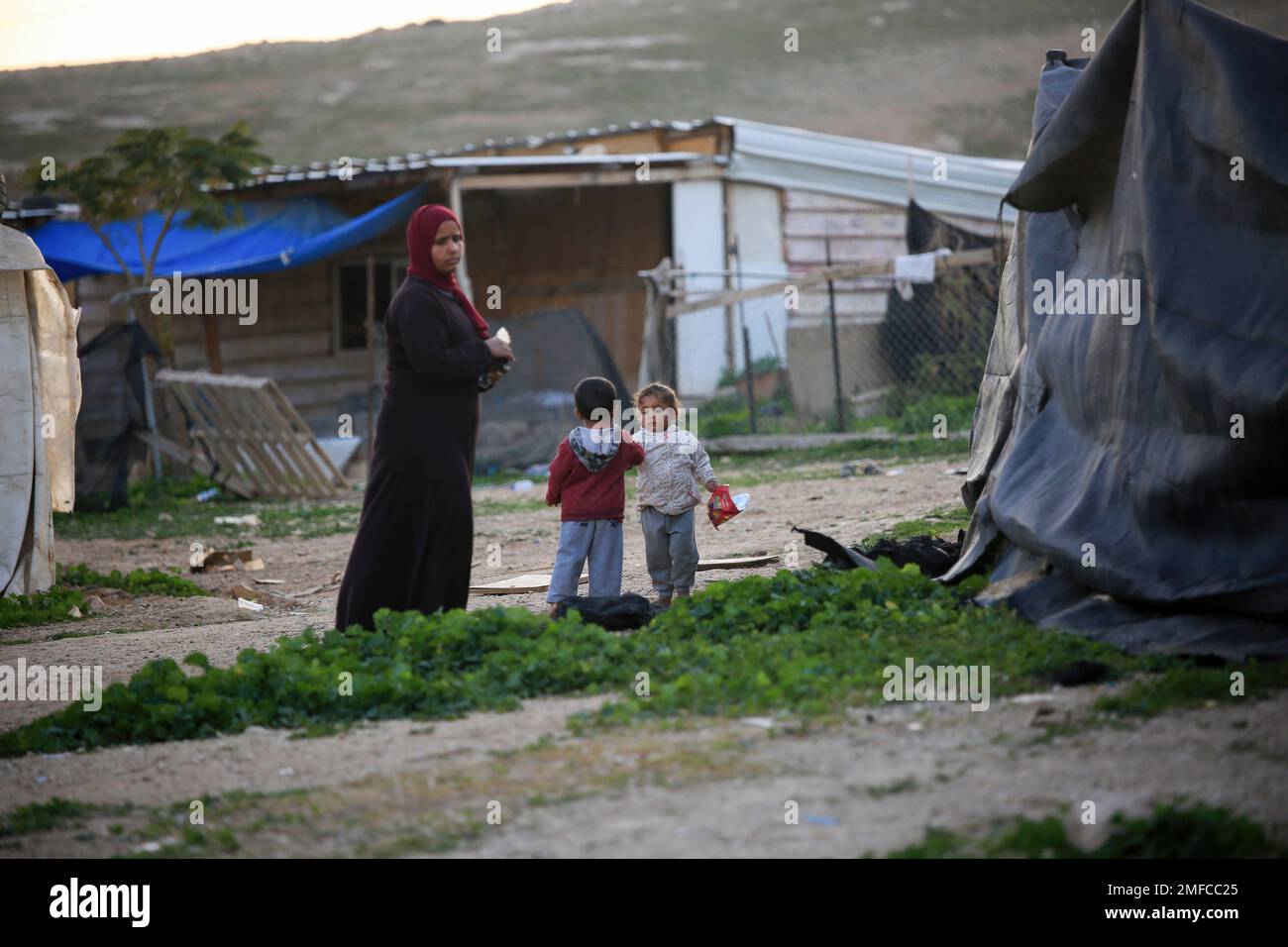 Jerusalén, Israel. 23rd de enero de 2023. Niños vistos jugando junto a una mujer en el pueblo de Khan al-Ahmar. Los residentes de la aldea de Khan al-Ahmar corren el riesgo de ser desalojados forzosamente, tras la visita de miembros del partido Likud de Netanyahu mientras el gobierno israelí se prepara para implementar la decisión de demoler la aldea beduina de Khan al-Ahmar en el campo. (Foto de Saeed Qaq/SOPA Images/Sipa USA) Crédito: SIPA USA/Alamy Live News Foto de stock