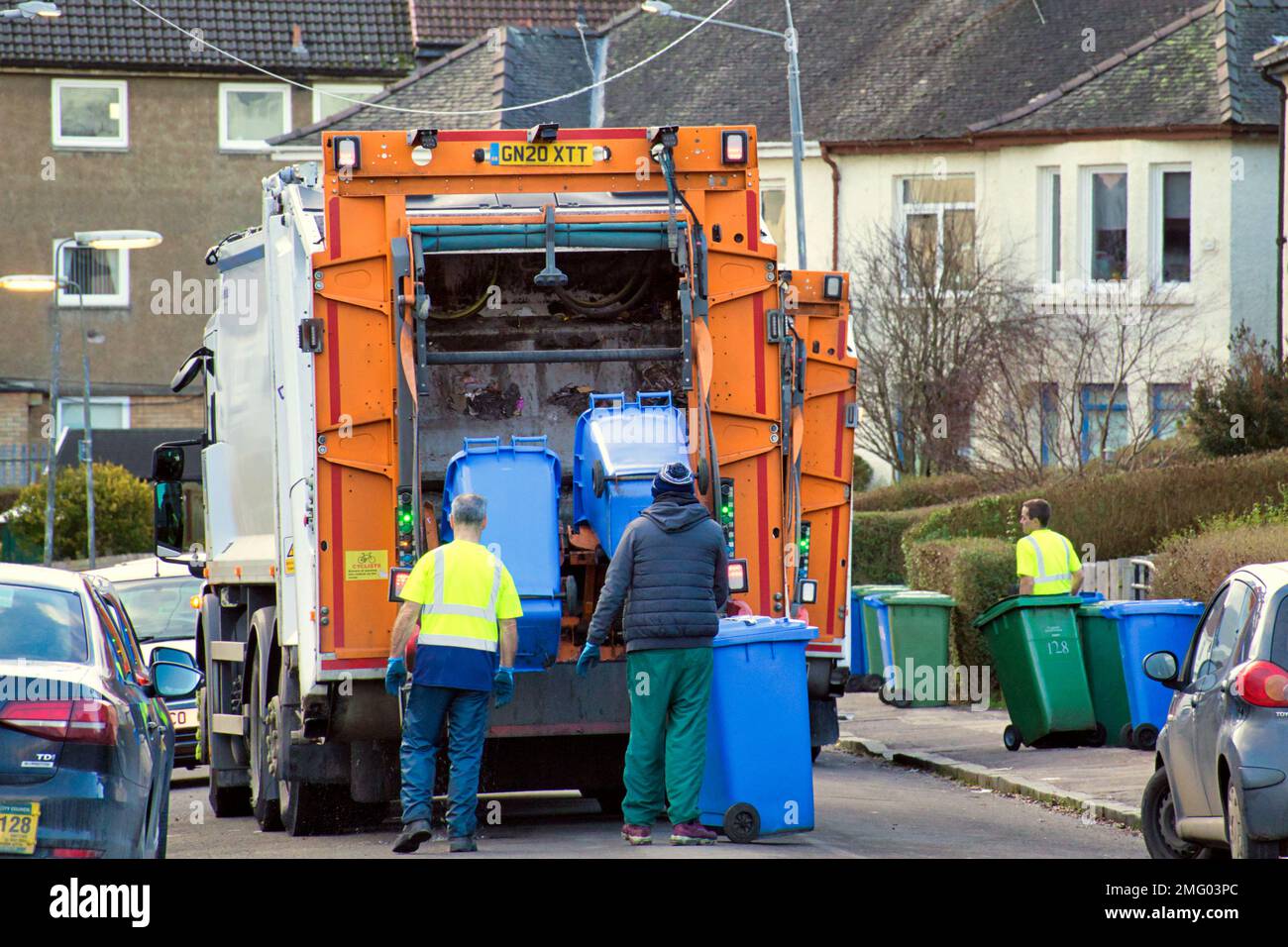 Bin camioneros de polvo recogiendo en la calle suburbana Foto de stock