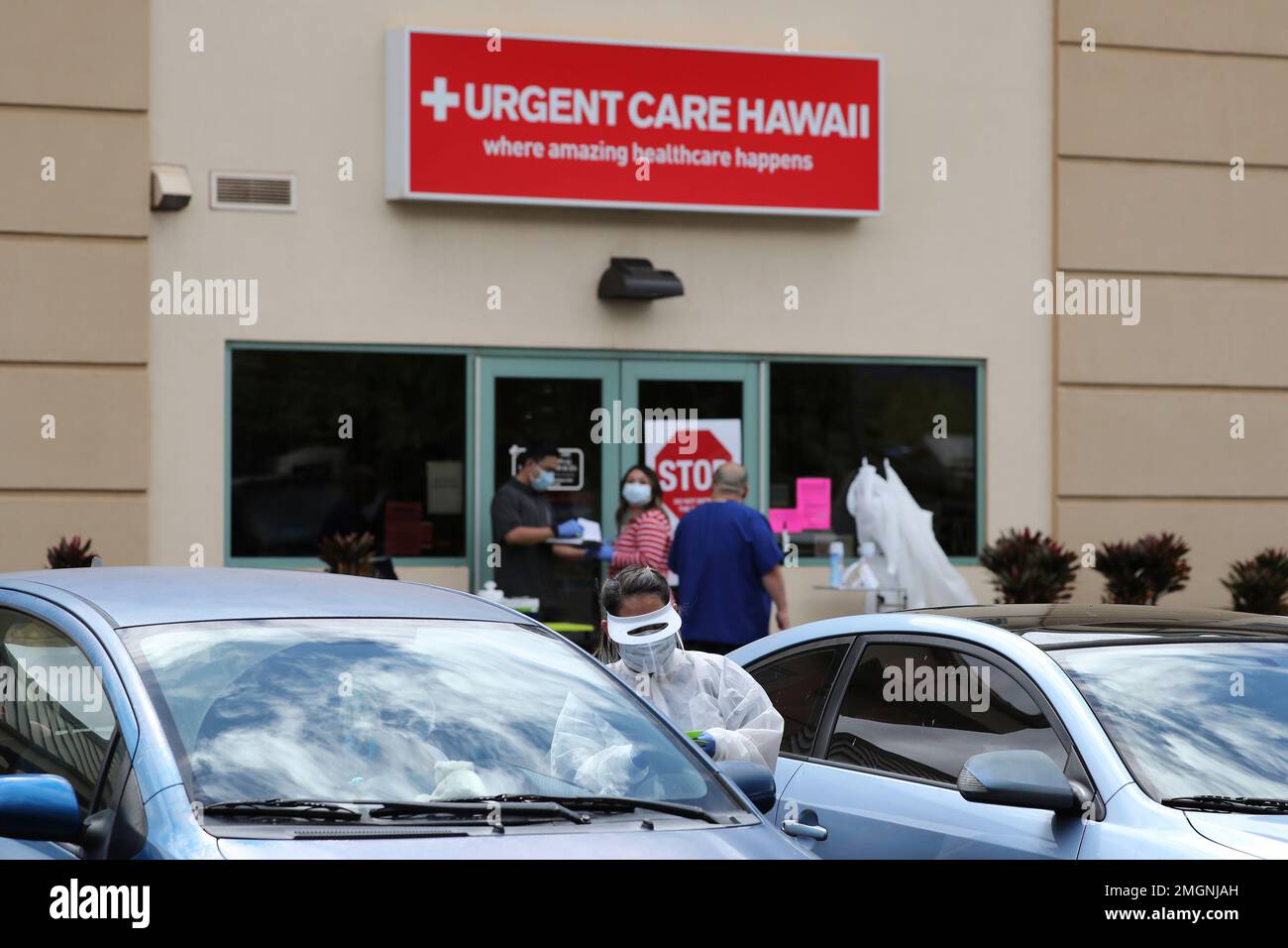 A medical worker talks to a person in their car outside an Urgent Care