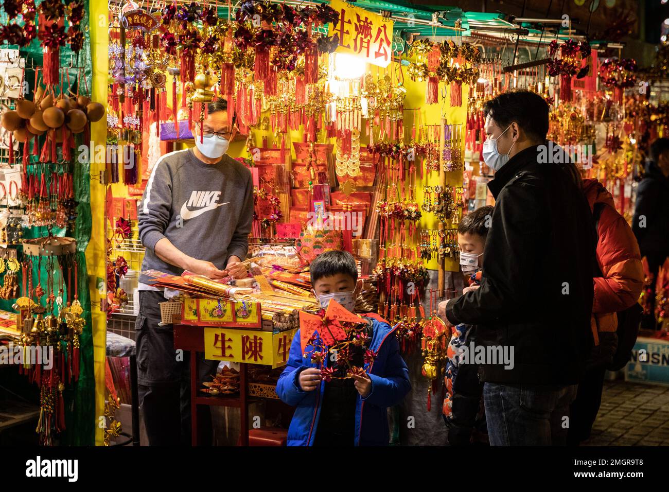 Hong Kong, Hong Kong. 21st de enero de Los miembros de la familia compran molinos de viento chinos en una tienda de decoración de Año Nuevo en las del