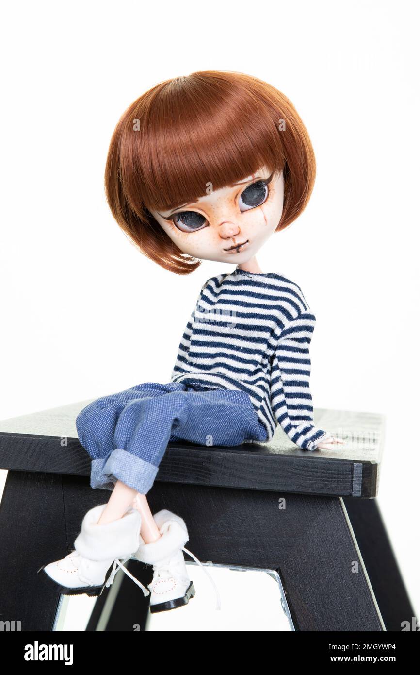 la muñeca se sienta en el banco de madera negro sobre fondo blanco chica de  moda bonita Fotografía de stock - Alamy