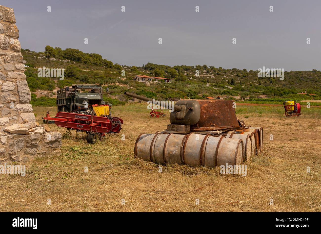 VIS, CROACIA, EUROPA - Equipo militar y agrícola, interior de la isla de Vis. Torreta de tanque viejo en barriles. Foto de stock