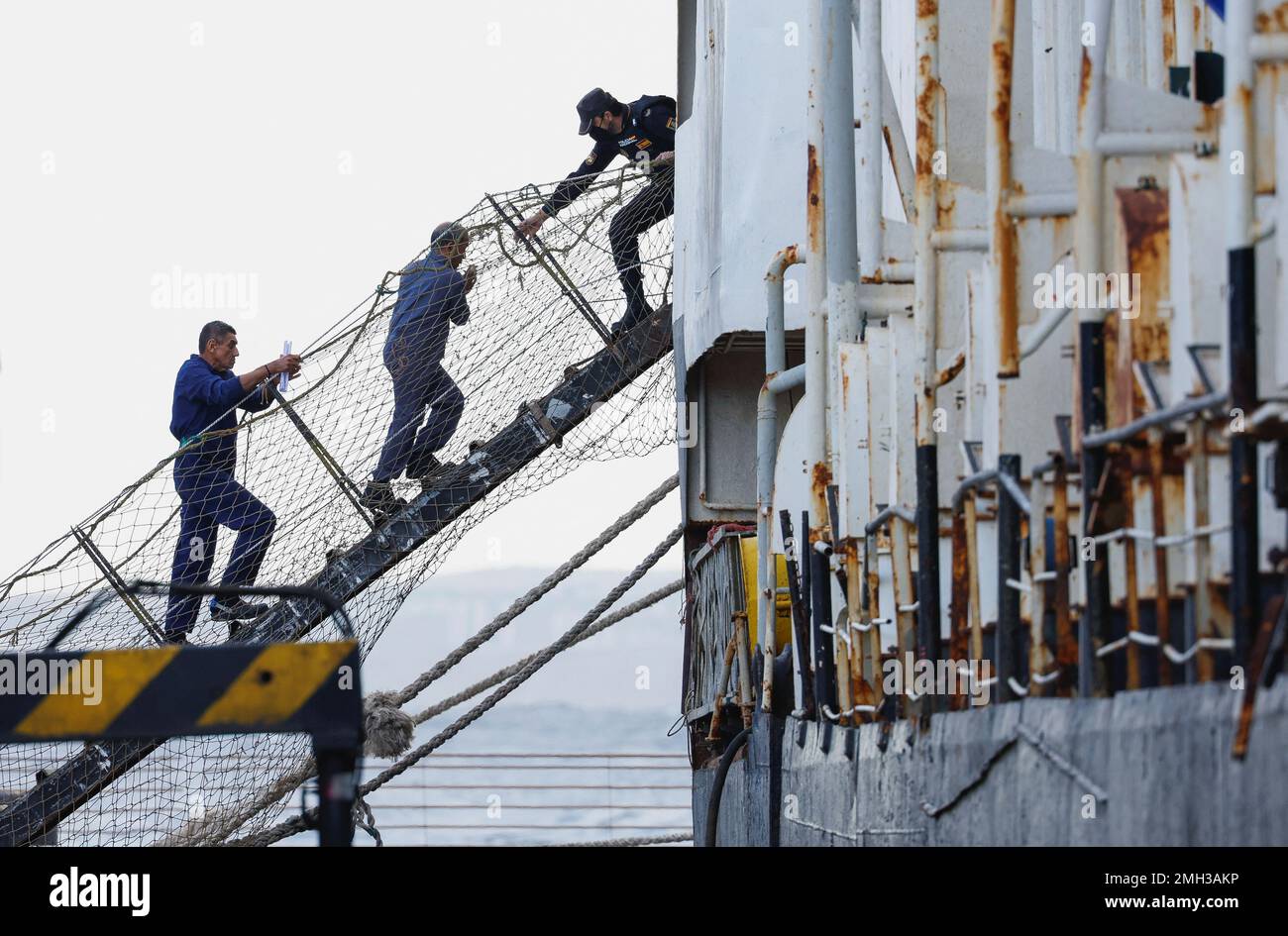 Un policía ayuda a dos detenidos del barco de ganado Orion V con drogas,  incautado en las Islas Canarias, en el puerto de Las Palmas, en la isla de  Gran Canaria, España,