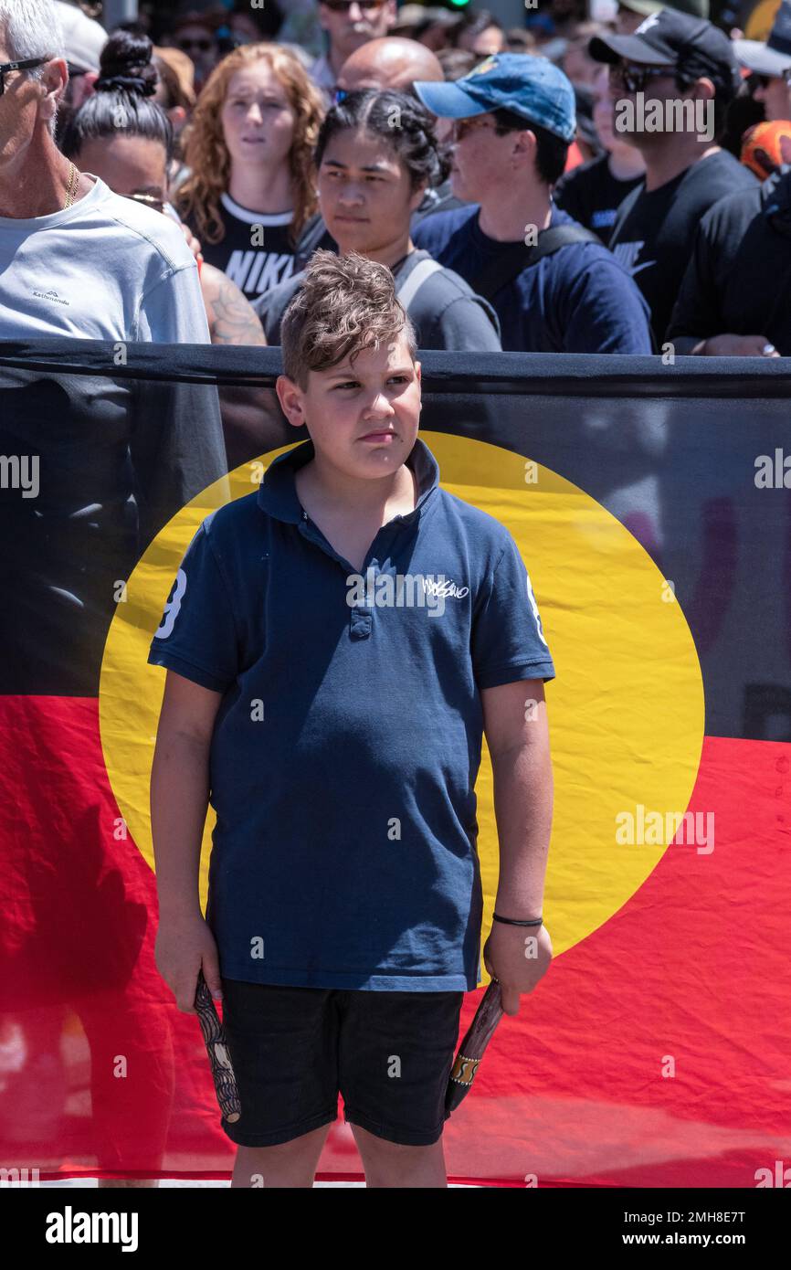 Melbourne, Australia, 26 de enero de 2023. Un joven se paró frente a la bandera aborigen durante la protesta anual del Día de la Invasión en Melbourne, organizada por los indígenas australianos y sus aliados, pide el fin de la celebración del Día de Australia y el reconocimiento de la Soberanía Indígena. Crédito: Michael Currie/Speed Media/Alamy Live News Foto de stock