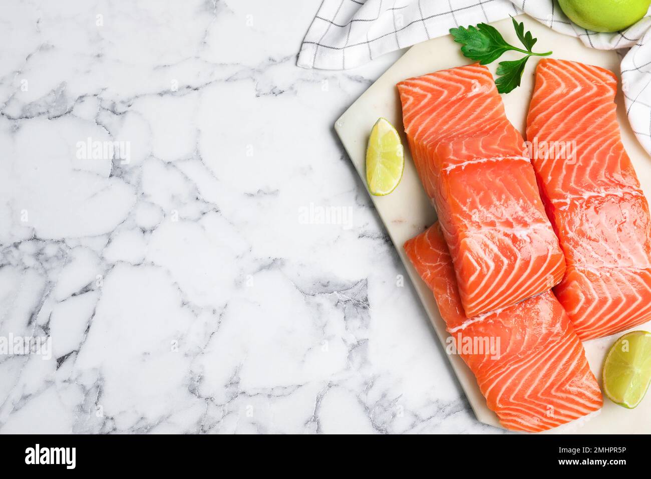 Vista superior de salmón crudo fresco con lima y perejil en la mesa de