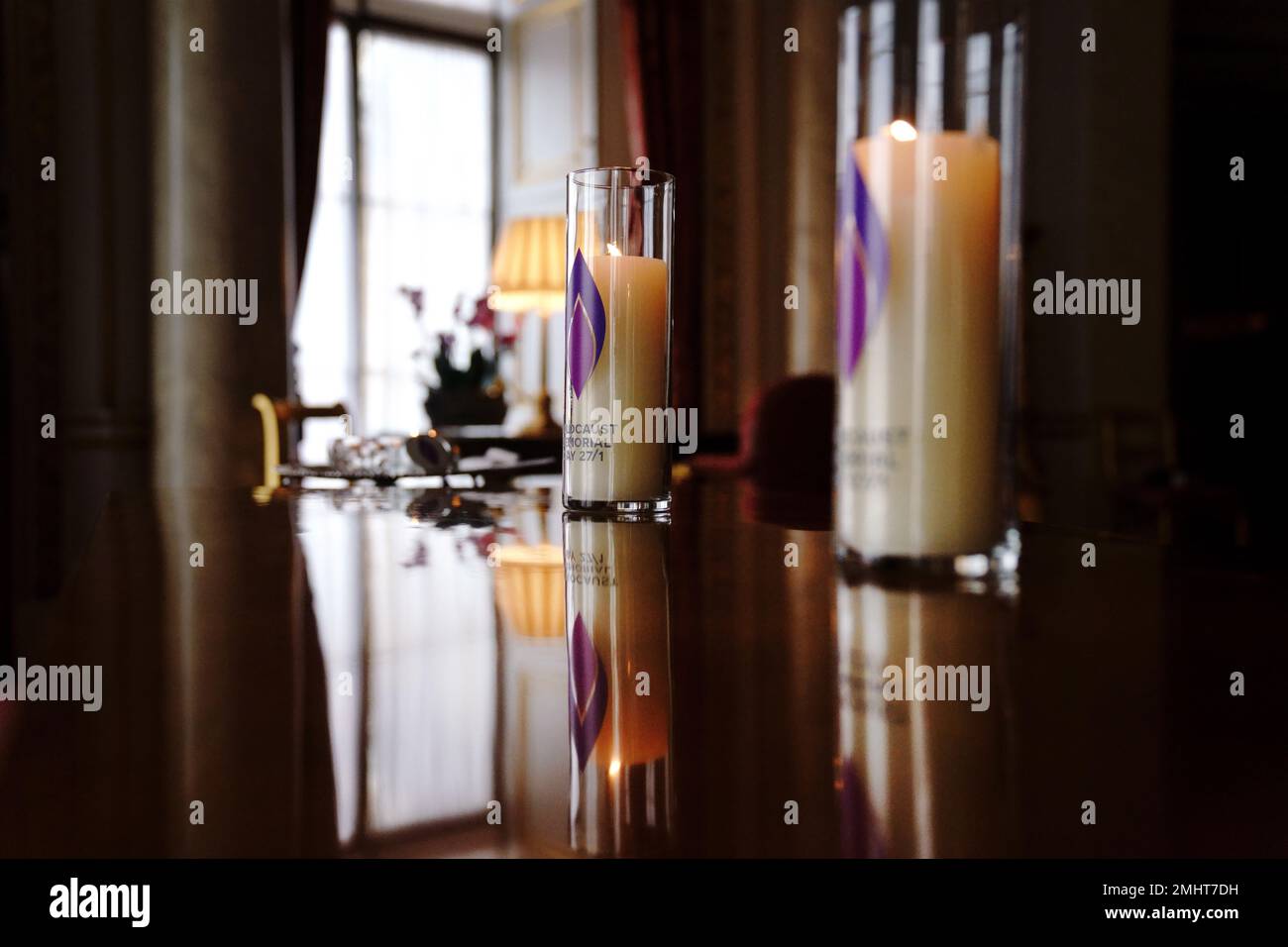 Las dos velas que el rey Carlos III y la reina consorte encendieron para conmemorar el Día de los Caídos del Holocausto en una ventana del Palacio de Buckingham, Londres. Fecha de la fotografía: Viernes 27 de enero de 2023. Foto de stock