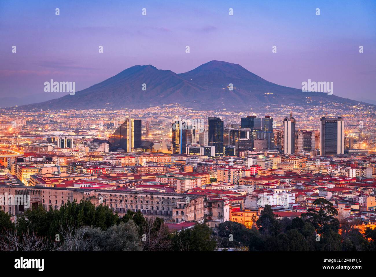 Nápoles, Italia, con el horizonte del distrito financiero bajo Mt. Vesubio al atardecer. Foto de stock