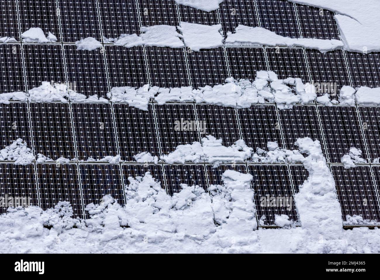 Colectores solares en un techo cubierto de nieve, Merklingen, Baden-Wuerttemberg, Alemania Foto de stock