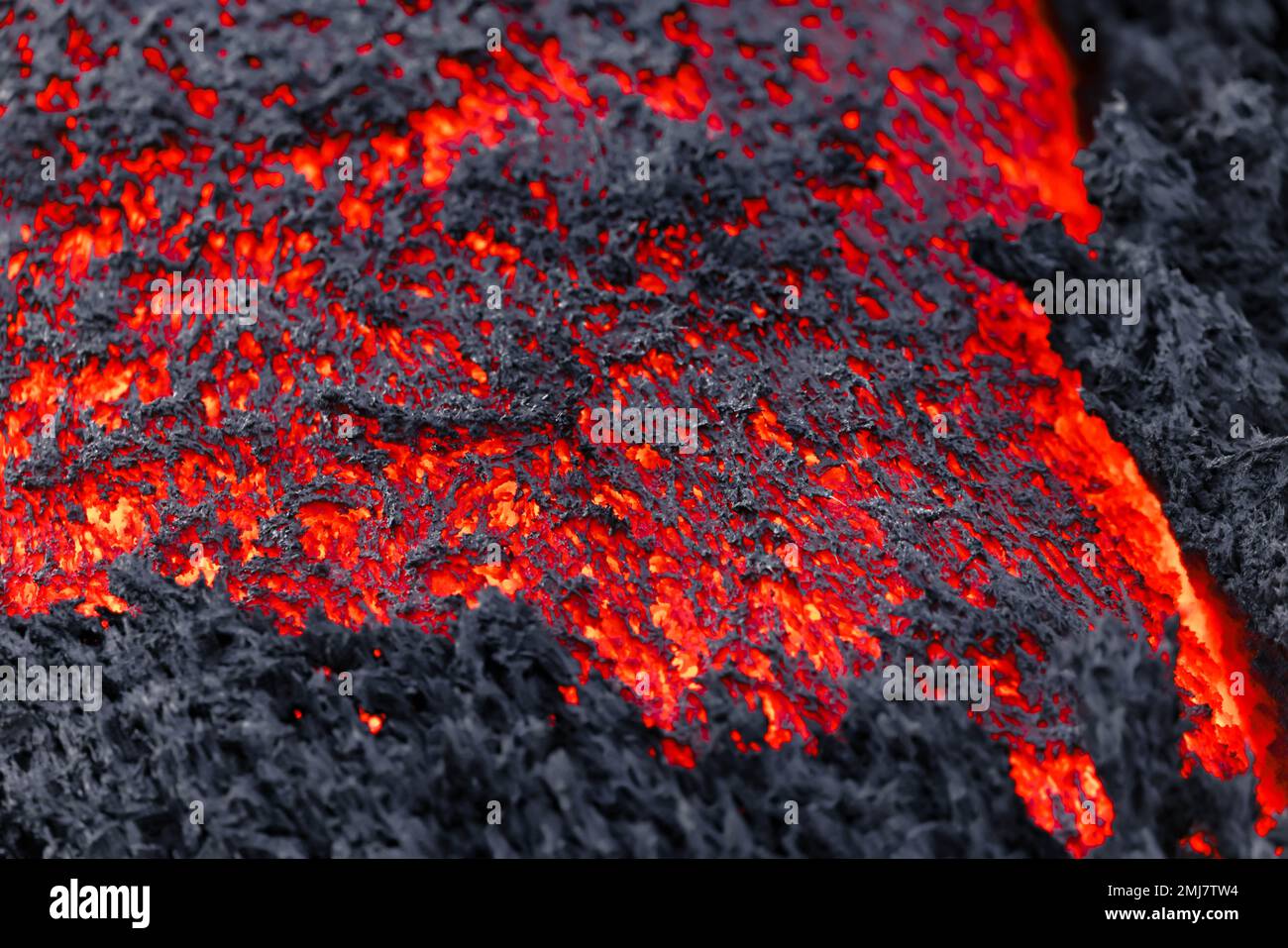 Flujo de lava en una vista de detalle - lava fundida vívida roja Foto de stock