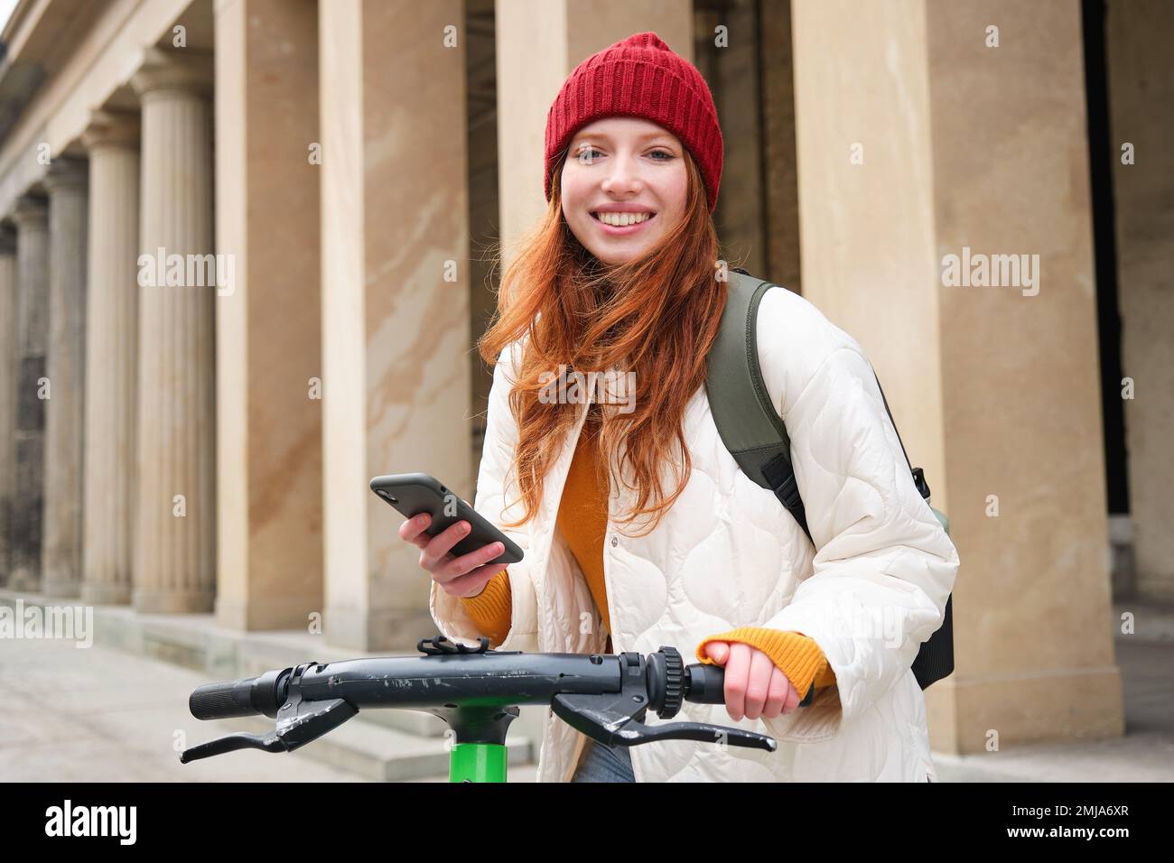 Joven hermosa estudiante asiática, con una mochila, camina en el parque con  un scooter eléctrico, en el verano en la calle Fotografía de stock - Alamy