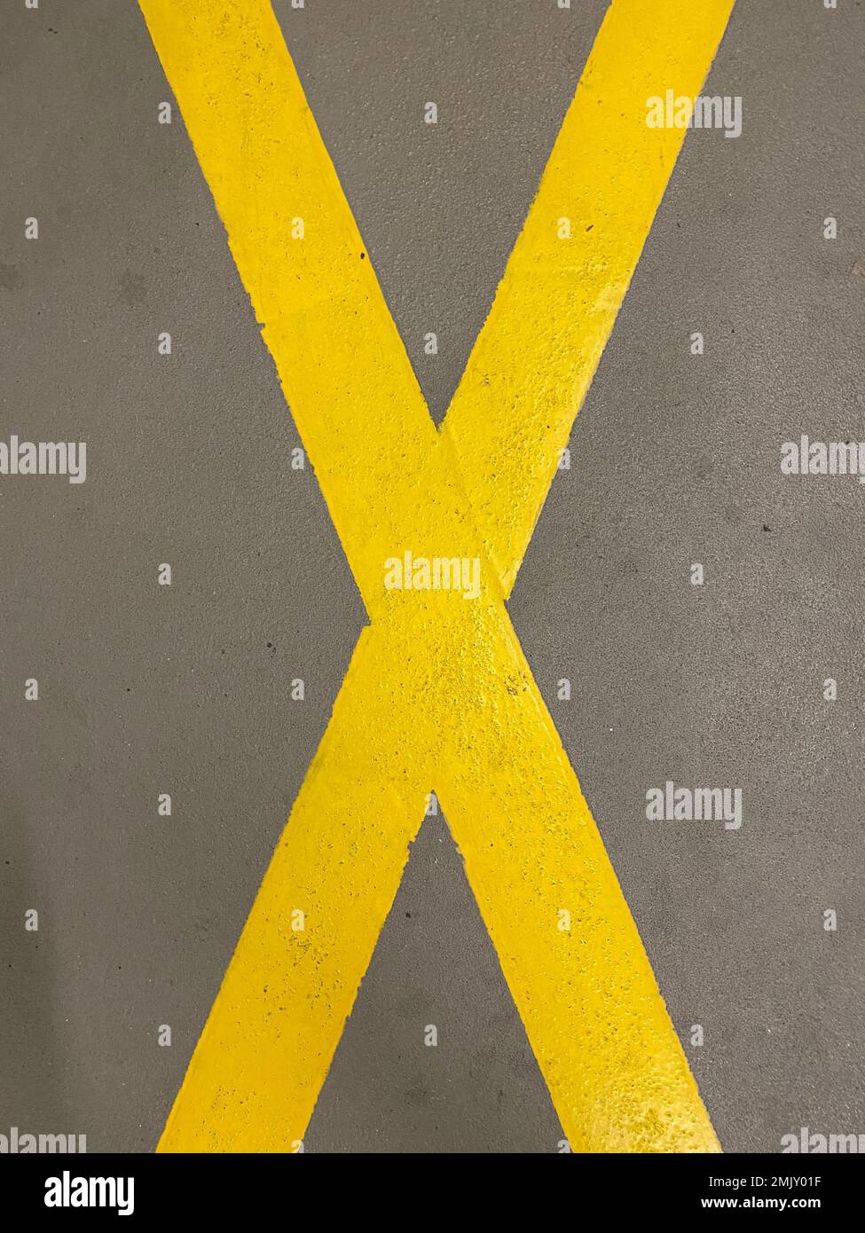 Cruz amarilla en la carretera con el significado de que el estacionamiento está prohibido