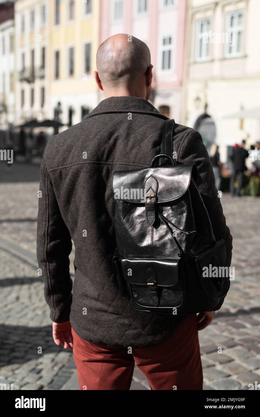 Parte de la foto de un hombre con una mochila de cuero negro con aspecto  antiguo y retro. Fotografía al aire libre Fotografía de stock - Alamy