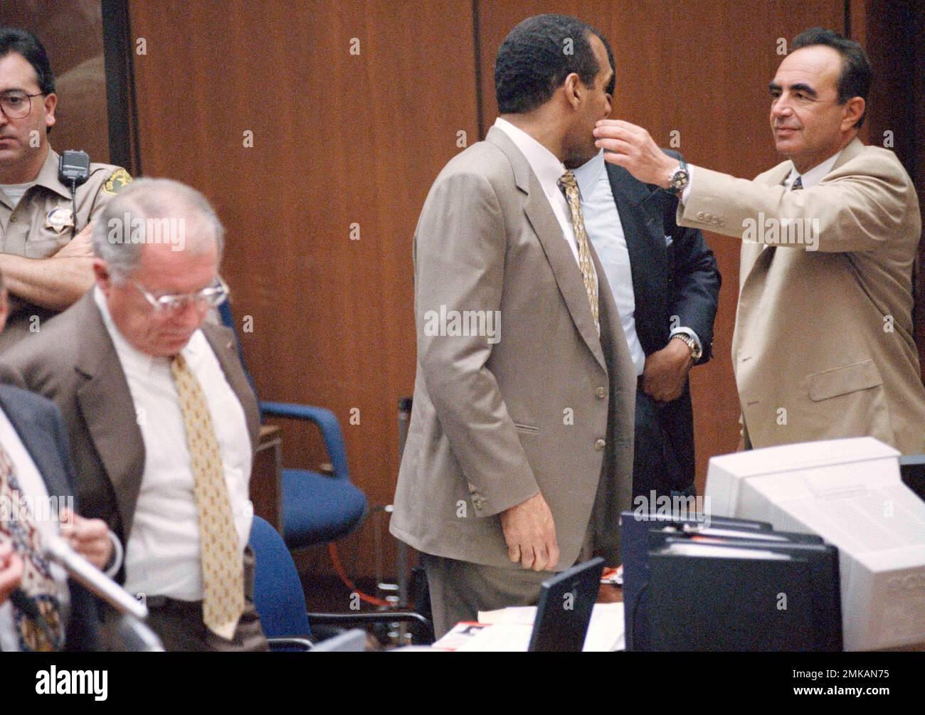 Defense attorney Robert Shapiro, right, wipes a speck off the face of O.J. Simpson during the