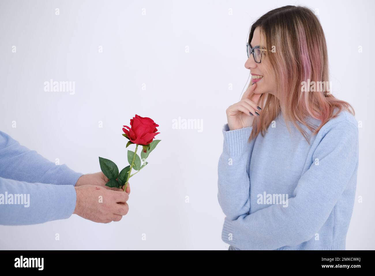 Escena de amor. Hombre dando rosa roja a su amante. Mujer feliz. Sorpresa. Foto de stock