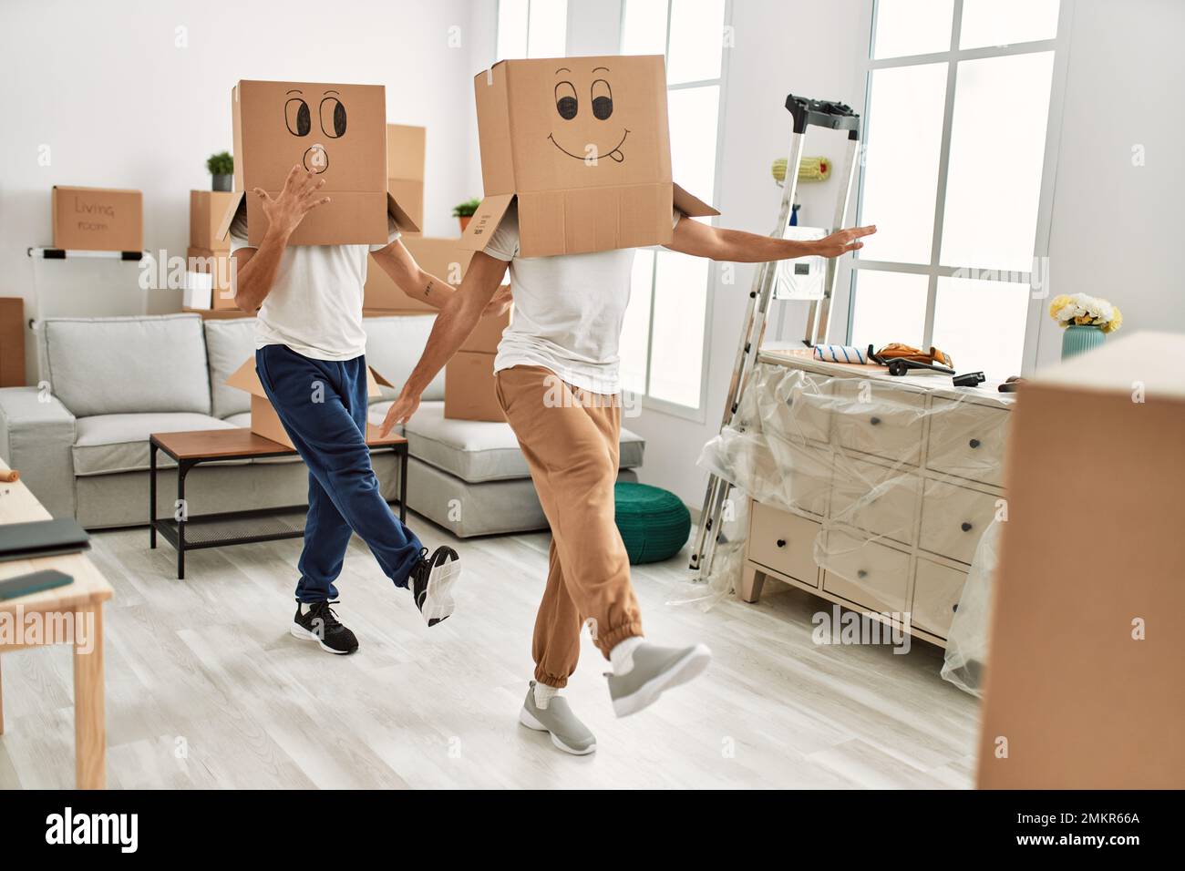 Dos hombres hispanos juegan con graciosas cajas de cartón en la cabeza en  la nueva casa Fotografía de stock - Alamy