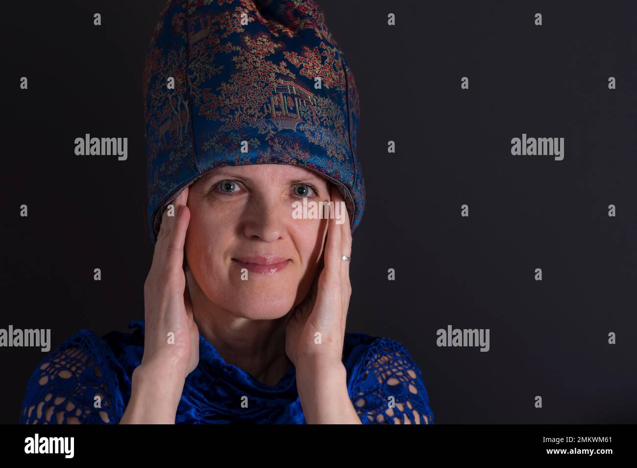 Bonito retrato de baja clave de mujer ucraniana madura en ropa oriental azul Foto de stock