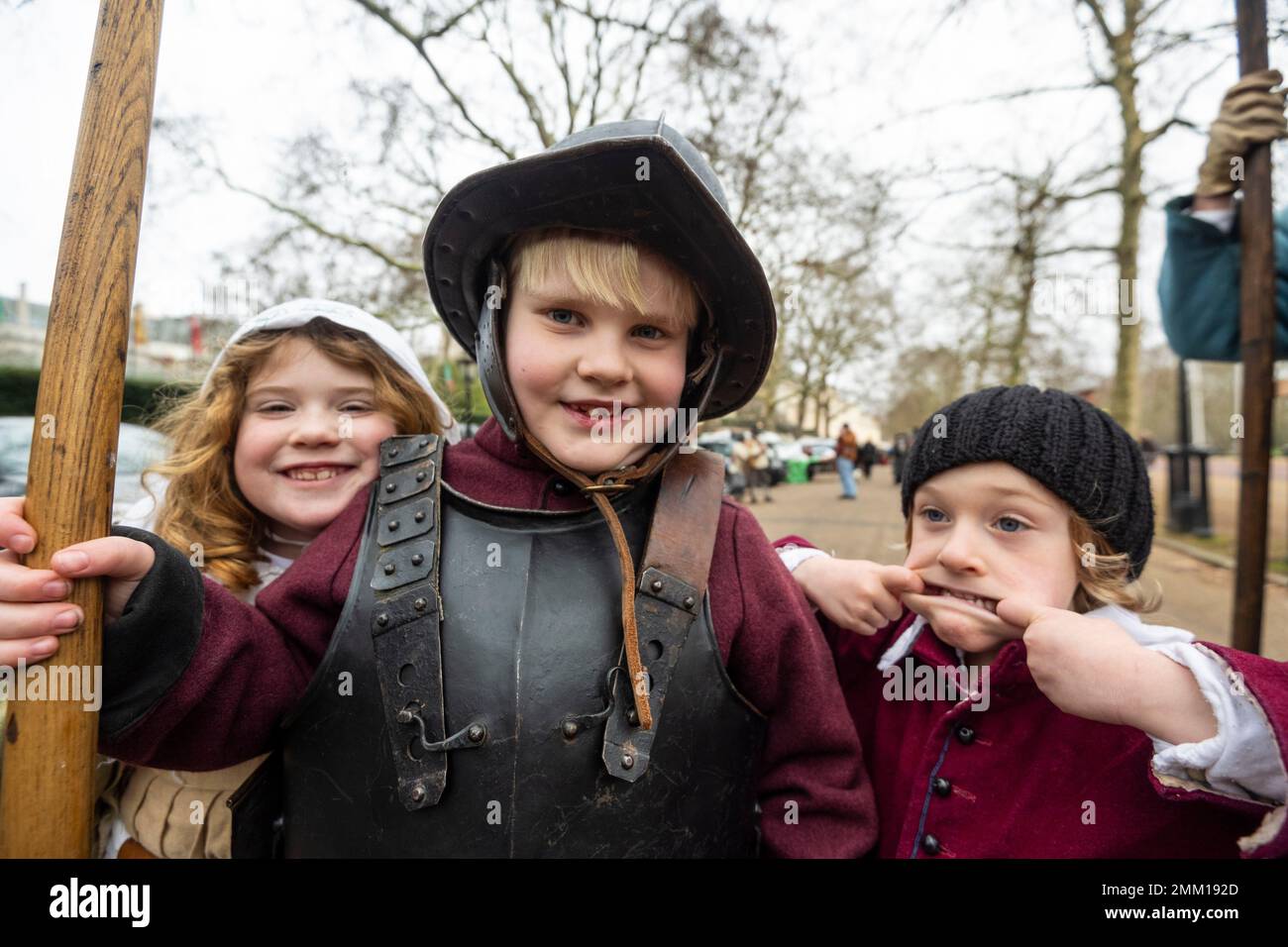 Londres, Reino Unido. 29 de enero de 2023. (De izquierda a derecha) Ivy, Joseph, ambos de 7 años, Y Wilf (de 4 años) de Yorkshire, se unen a los miembros del Ejército del Rey (la mitad realista de la Sociedad Inglesa de la Guerra Civil), en el Mall, retomando el viaje final en 1649 del Rey Carlos I, quien fue llevado desde el Palacio de Santiago a la Casa de Banquetes en Whitehall para ser decapitado. La marcha con todo el disfraz está compuesta por voluntarios vestidos con trajes realistas y tropas montadas con armas que conmemoran lo que llaman 'el horrible asesinato de Su Majestad'. [PERMISO DE LOS PADRES OTORGADO] Crédito: Stephen Chung / Alamy Live News Foto de stock