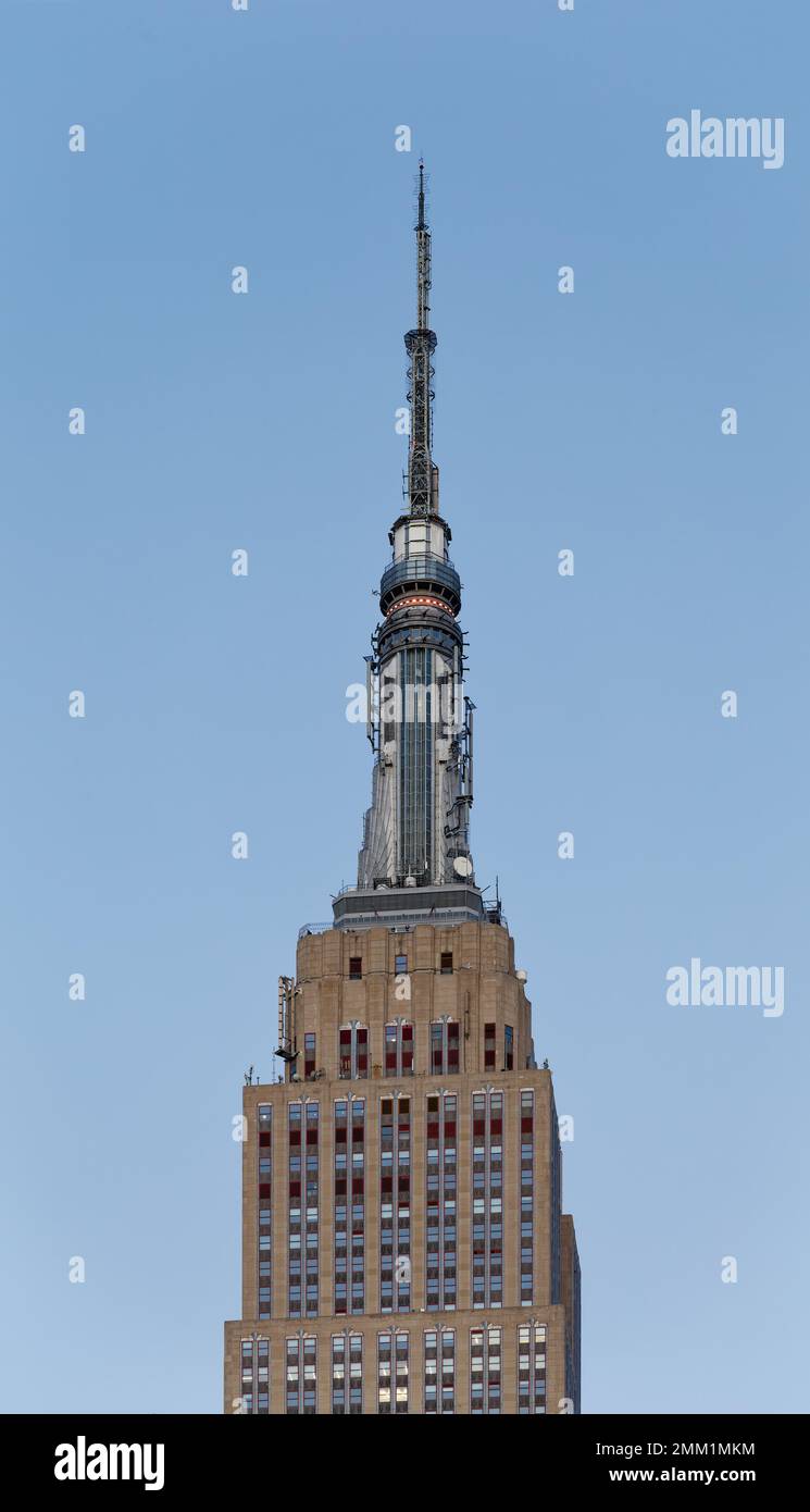 NYC: La fachada oriental del Empire State Building pasa de gris a rojo dorado al amanecer, cuando el sol está en su punto más bajo. Foto de stock