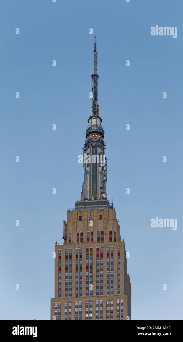 NYC: La fachada oriental del Empire State Building pasa de gris a rojo dorado al amanecer, cuando el sol está en su punto más bajo. Foto de stock