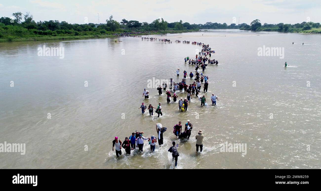 Salvadoran migrants cross the Suchiate river, the border between