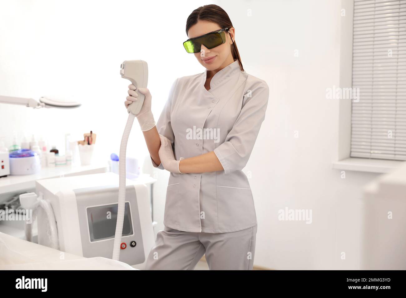 Mujer joven que sostiene la depiladora láser profesional en el salón de  belleza Fotografía de stock - Alamy