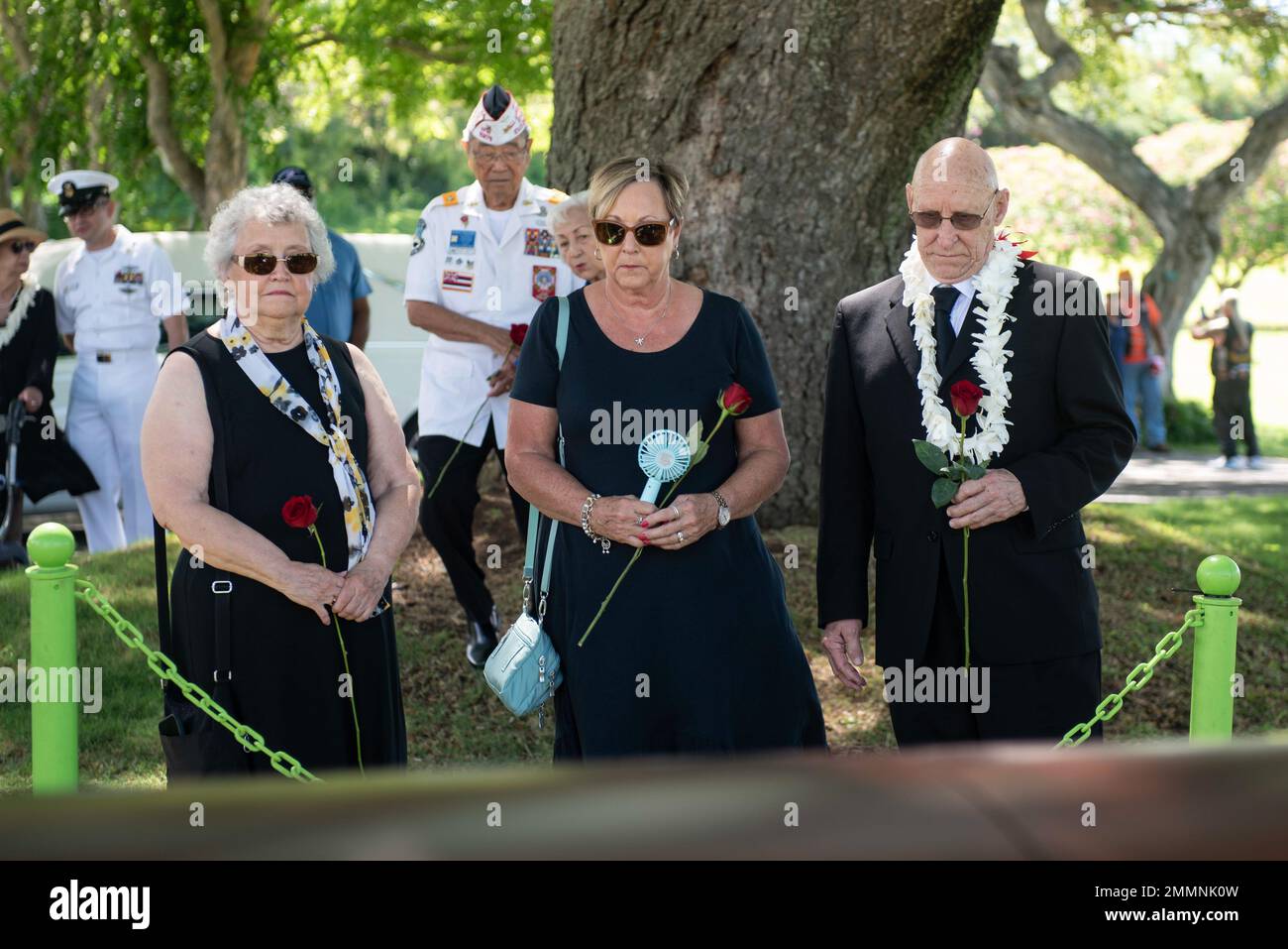 De izquierda a derecha, Cathy Williams, sobrina del Oficial Petty 1st Class  Beoin Corzatt, Kim Sutton, sobrina de Corzatt, y George Corzatt, sobrino de  Corzatt, Vea el ataúd durante una ceremonia de