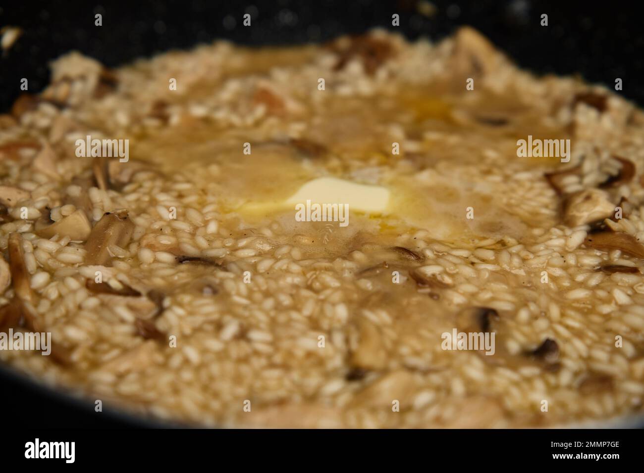 Proceso de cocción del risotto. Arroz arborio en sartén en la cocina