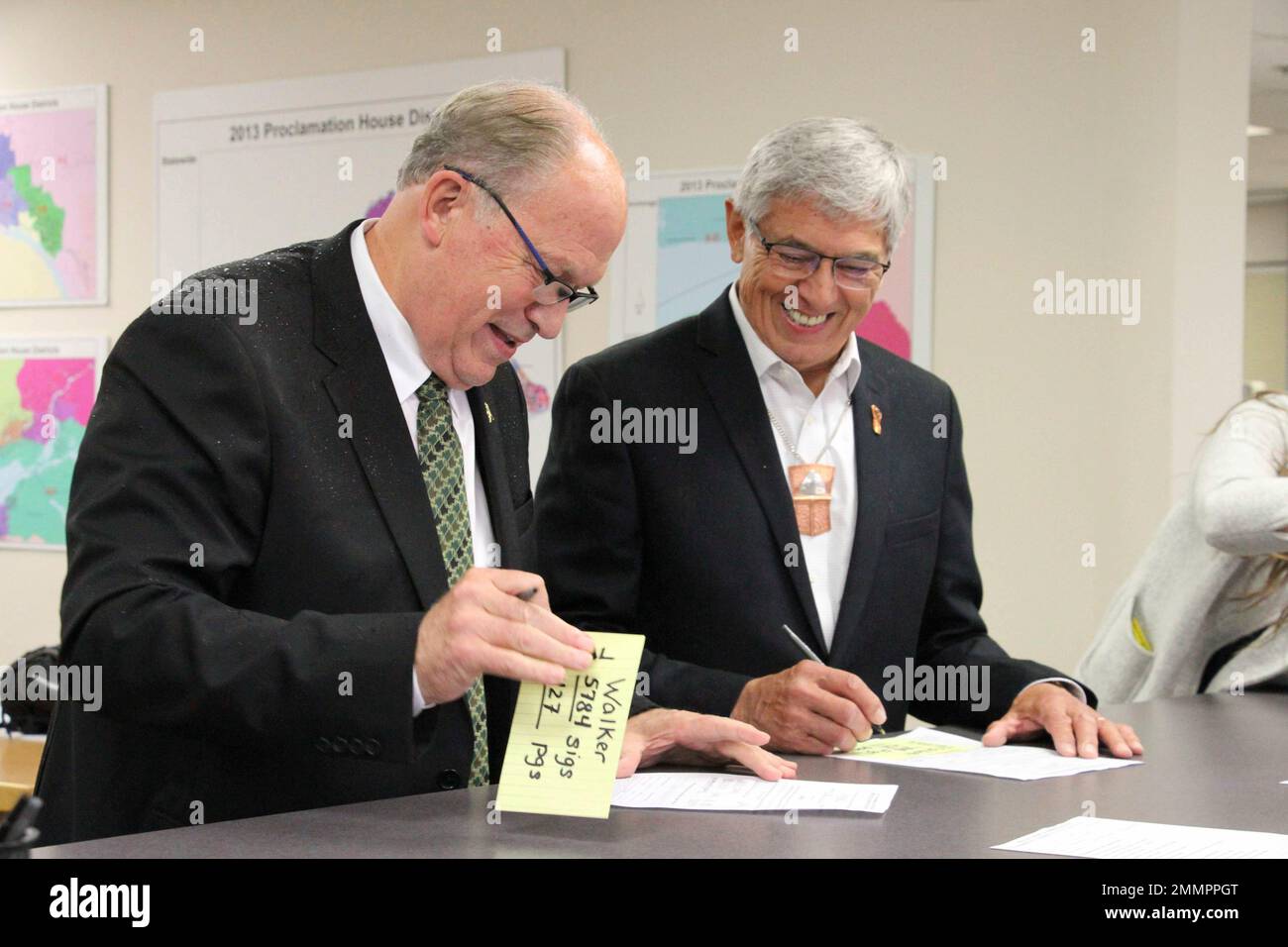 Alaska Gov. Bill Walker, left, and Lt. Gov. Byron Mallott sign forms at