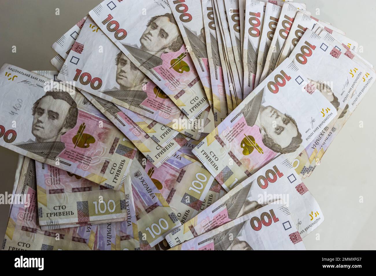 El papel moneda ucraniano se presenta sobre un fondo azul. billetes de 100 hryvnia. Foto de stock