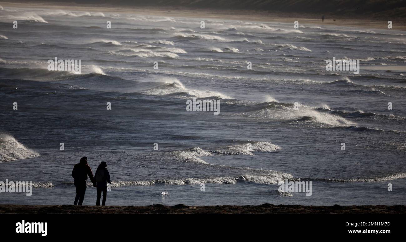 La gente camina a lo largo de la playa cerca de Redcar, Gran Bretaña, 30 de enero de 2023. REUTERS/Phil Noble Foto de stock