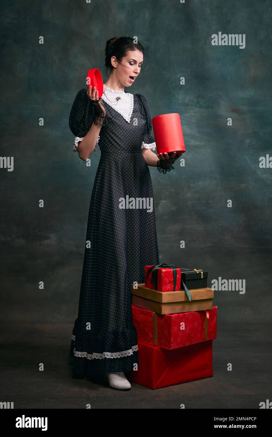 Con cajas de regalo. Mujer hermosa joven en imagen de Anna Karenina en  vestido negro retro posando sobre fondo vintage oscuro. Concepto de  literatura Fotografía de stock - Alamy