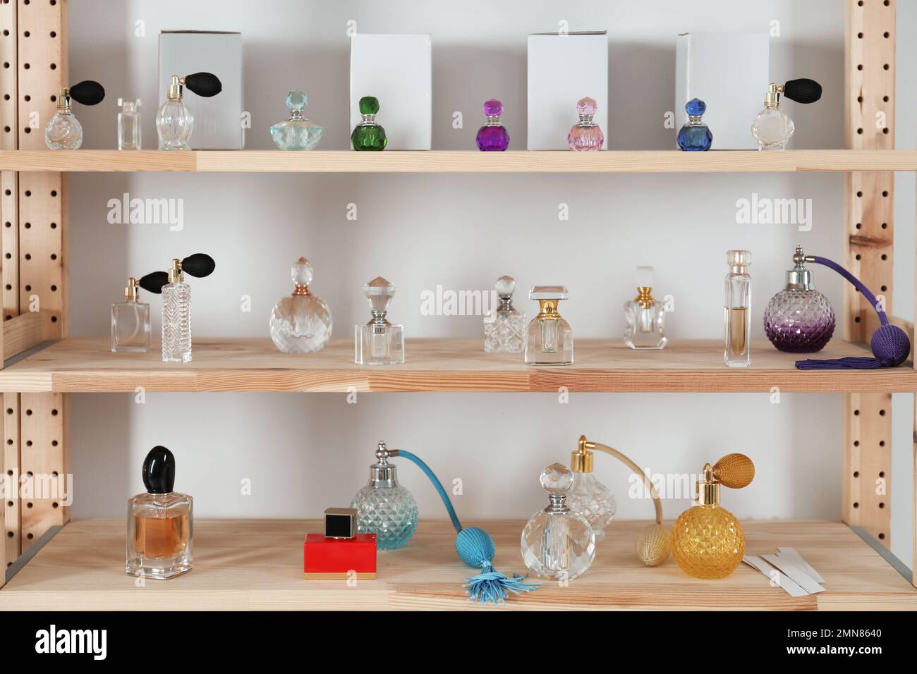 Diferentes botellas de perfume en rack de madera en el interior Fotografía  de stock - Alamy
