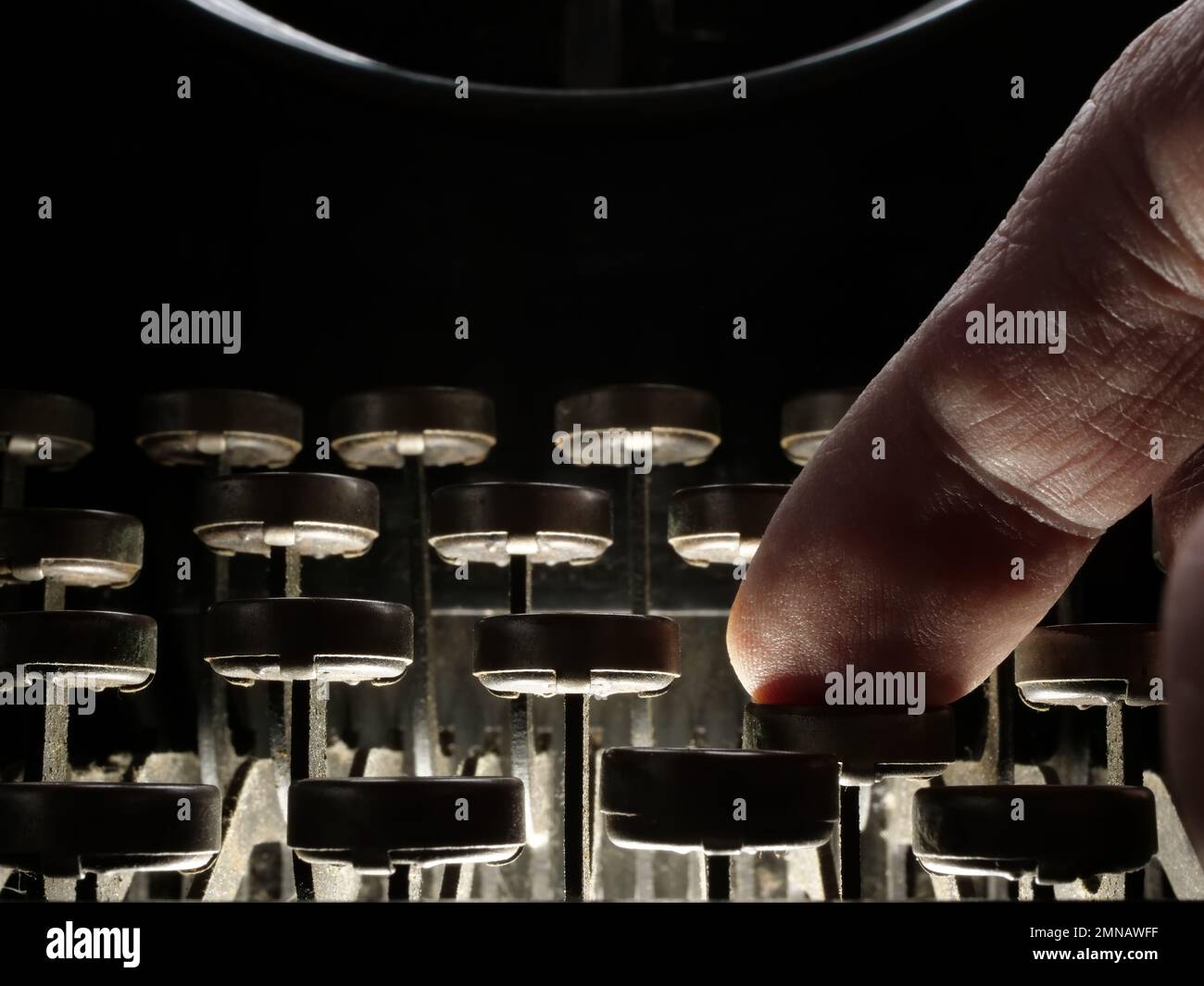 Primer plano de un dedo presionando un botón de la máquina de escribir como concepto de narración. Foto de stock