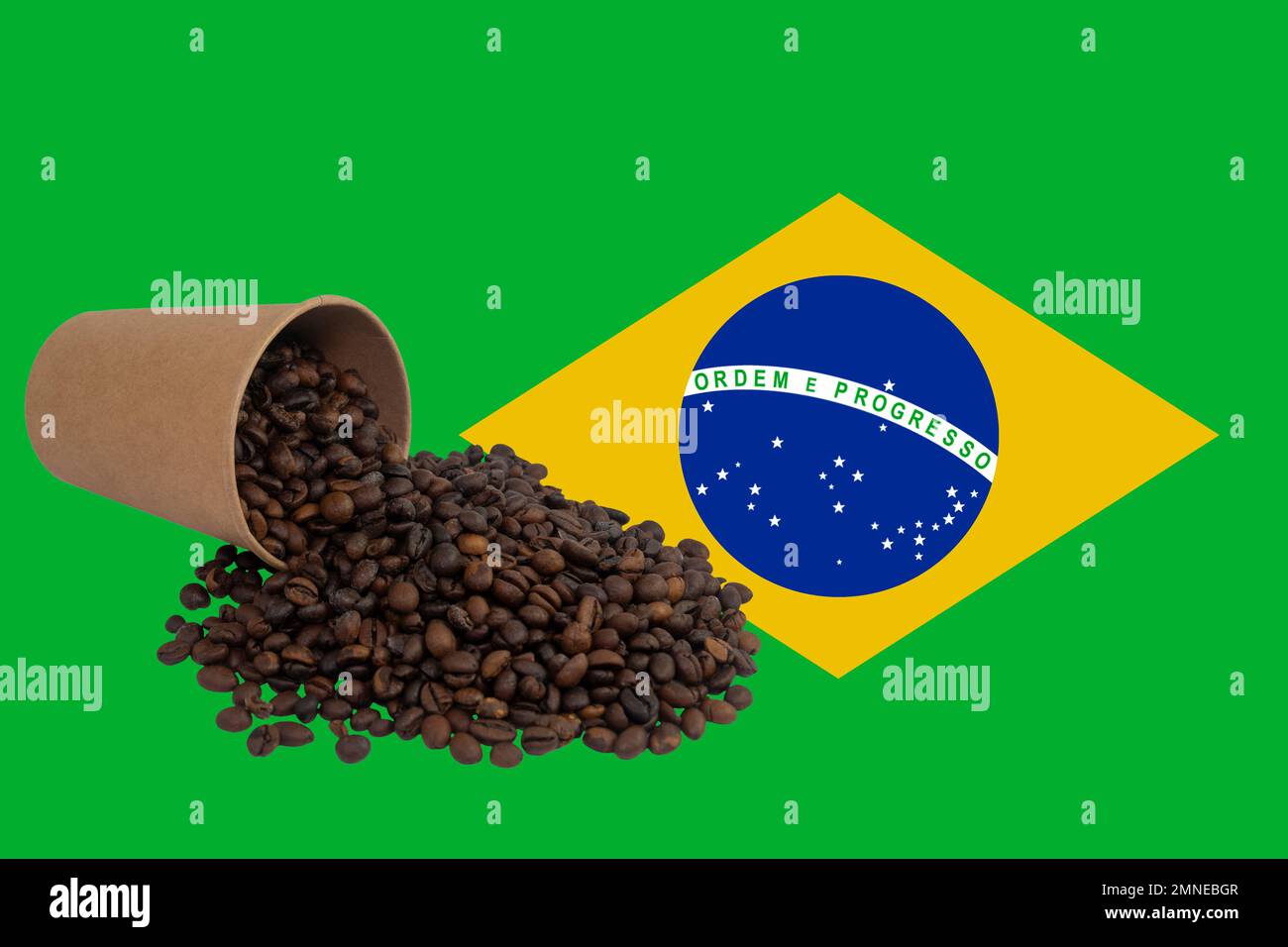 Una taza de papel desechable volcada llena de granos de café tostados contra el fondo de la bandera de Brasil (primer plano) Foto de stock