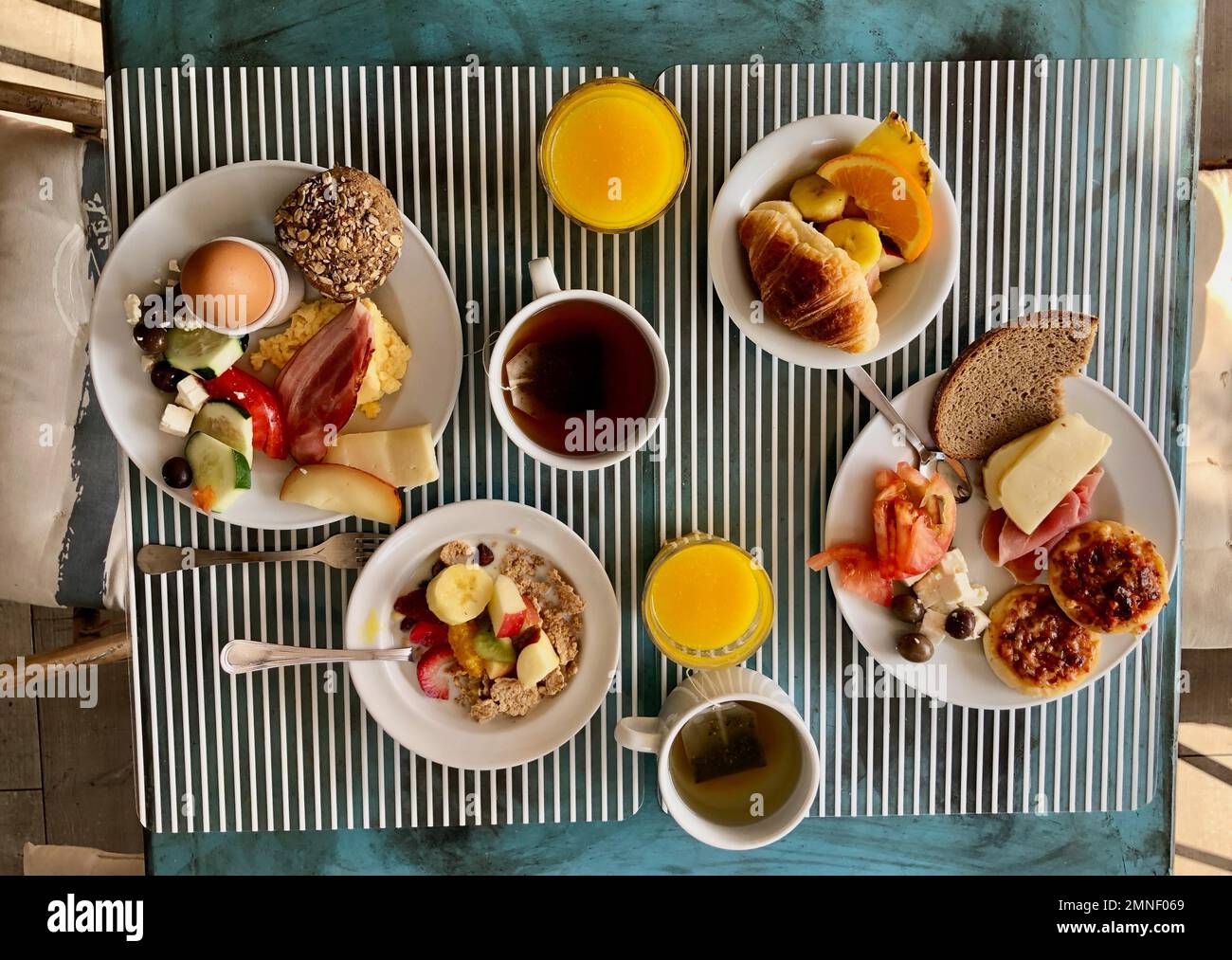 Set mesa con desayuno para dos, pan, queso, huevos y cereales, Portugal Foto de stock