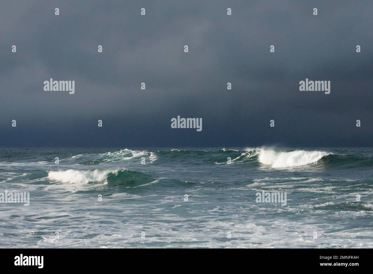 Grandes olas rompiendo en mar abierto y una luz espectacular frente a la costa norte de Irlanda, Fintra Beach en el condado de Donegal Foto de stock