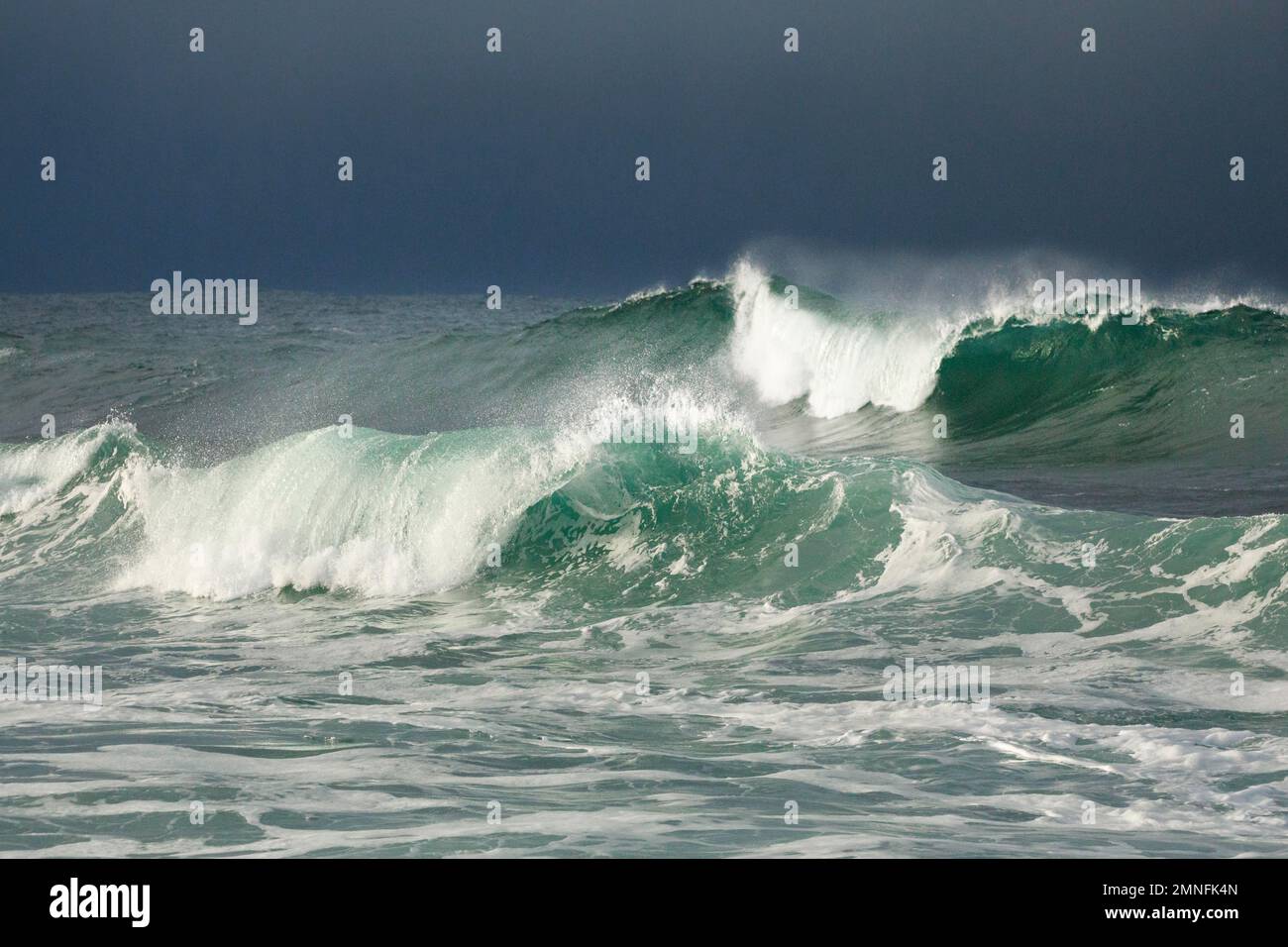 Grandes olas rompiendo en mar abierto y una luz espectacular frente a la costa norte de Irlanda, Fintra Beach en el condado de Donegal Foto de stock