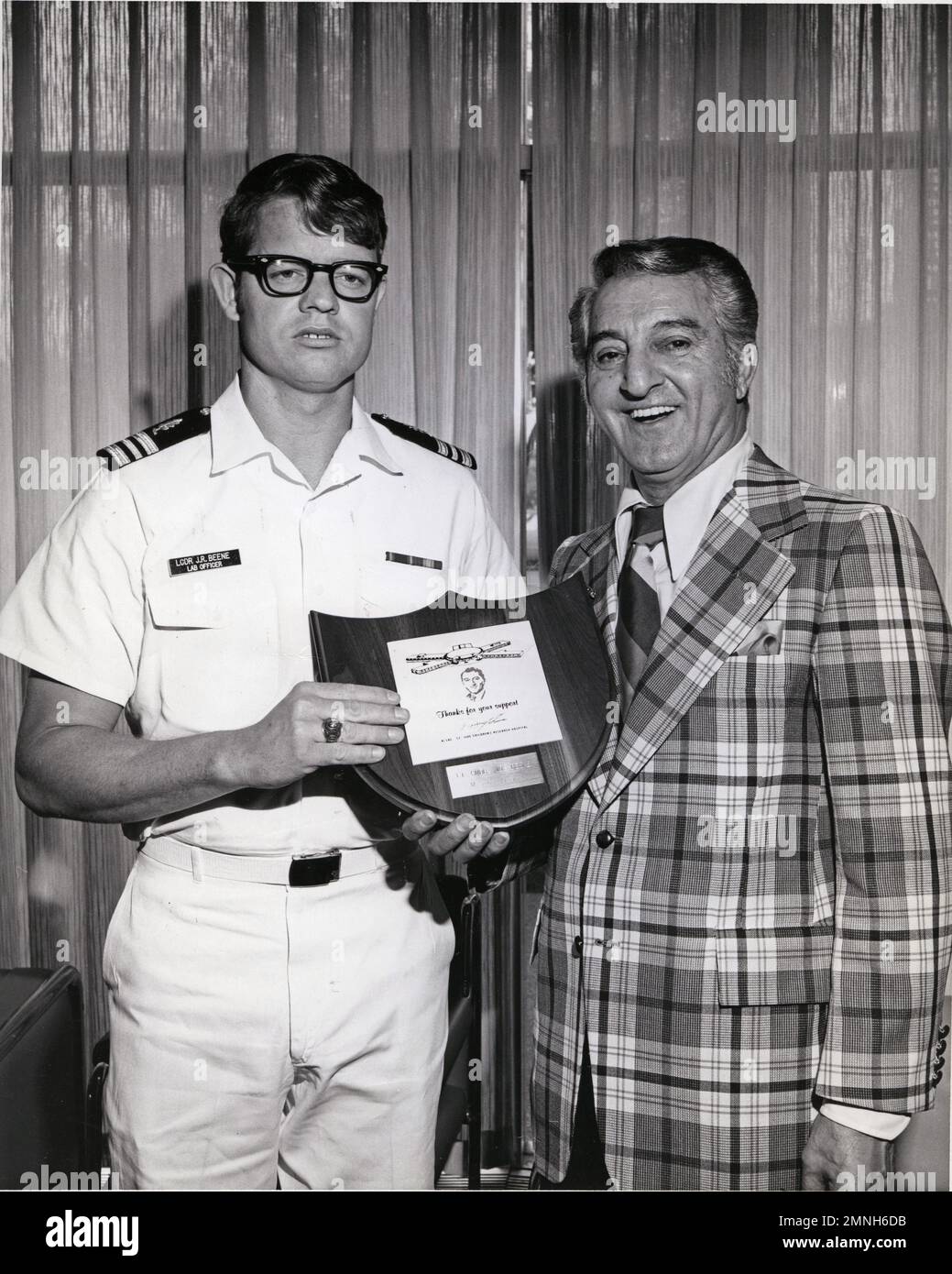 Teniente Comandante J.R. Beene recibe una placa del artista Danny Thomas en reconocimiento al papel del oficial naval en el suministro de plaquetas de sangre a St. Jude Children's Research Hospital Ca. Agosto de 1975 Foto de stock