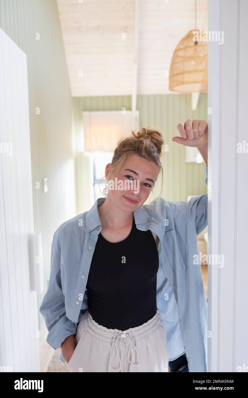 Retrato de adolescente (16-17) de pie en la puerta Foto de stock