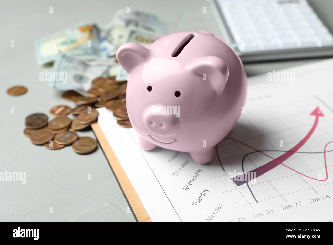 Hucha rosa y dinero en la mesa gris claro Fotografía de stock - Alamy
