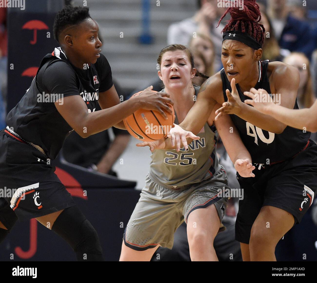 Connecticut's Kyla Irwin, center, cuts between a pass from Cincinnati's