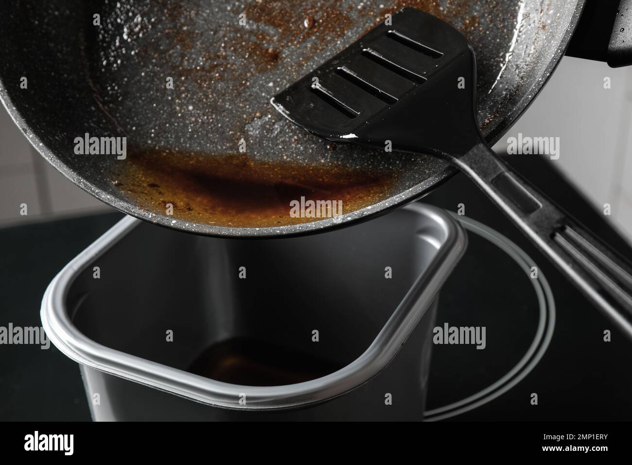 Verter el aceite de cocina usado de la sartén en el recipiente, primer  plano Fotografía de stock - Alamy