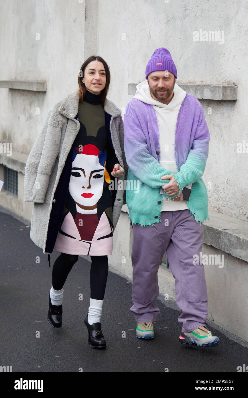 MILÁN, ITALIA - 15 DE ENERO de 2023: Mujer y hombre con piel gris y suéter de gradiente suave púrpura y turquesa antes del desfile de Prada, Milan Fashion W Foto de stock