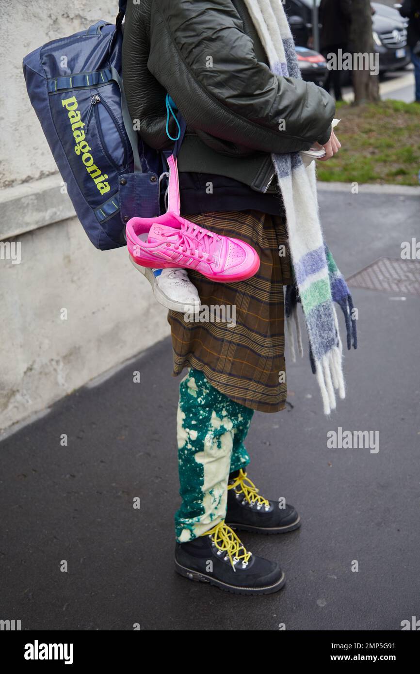 MILÁN, ITALIA - 15 DE ENERO de 2023: Hombre con zapatillas Adidas rosa y  blanco y bolso