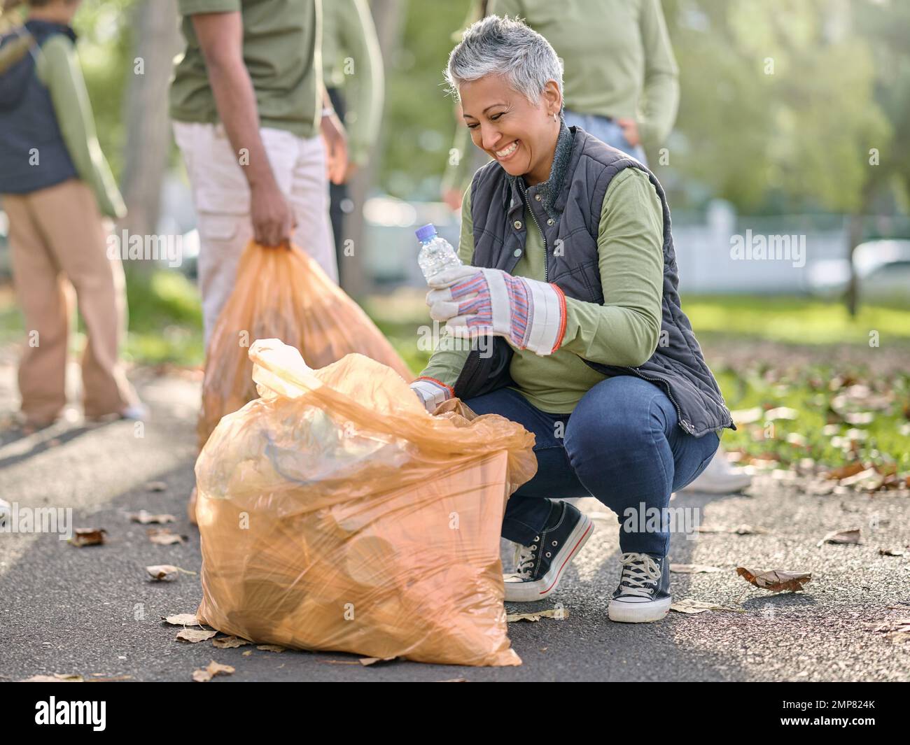Basura, voluntaria y anciana que limpia la basura, la contaminación o el  producto de desecho para el apoyo del medio ambiente. Contenedor de bolsa  de plástico, ONG de caridad y eco Fotografía